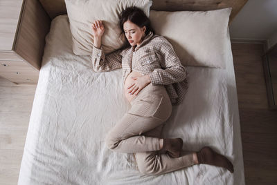 Midsection of woman sitting on sofa at home