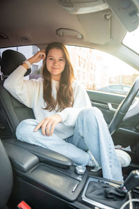 Portrait of young woman sitting in car