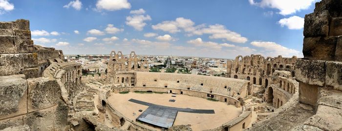 Aerial view of cityscape against cloudy sky