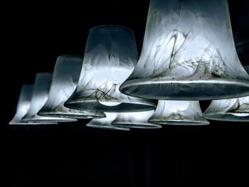 Close-up of electric lamp on table against black background