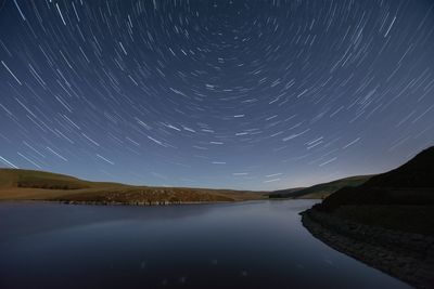 Scenic view of lake against sky at night