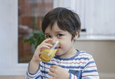 Portrait of boy drinking juice at home