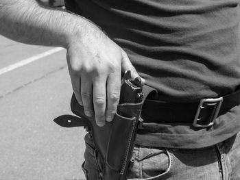 Mid section of a man holding gun