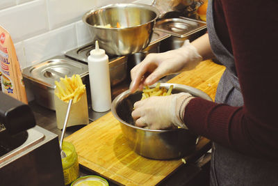 Midsection of woman preparing food in kitchen at home