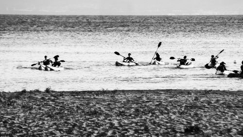 People at beach against sky