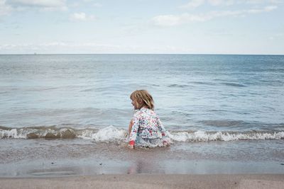 Girl playing in the water at the beach having fun