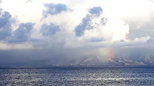 Sunlight streaming through clouds over sea