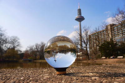 Close-up of crystal ball against sky