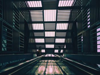 Rear view of man on moving walkway in building