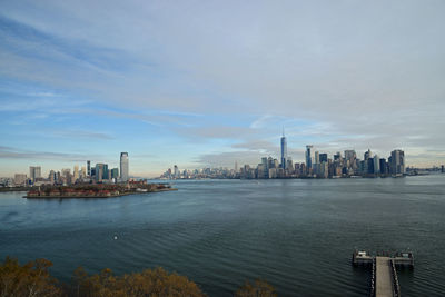 View of city by sea against sky