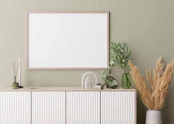 Empty horizontal picture frame on light green wall in modern living room. mock up interior