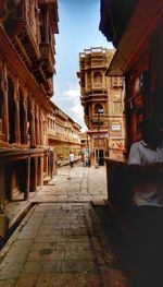 Man walking in city against sky