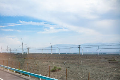 Wind turbines on land against sky