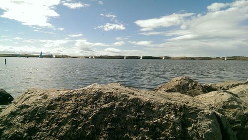 Scenic view of river against cloudy sky