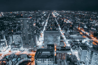 High angle view of illuminated buildings in city at night