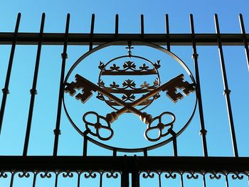 Low angle view of ornate gate against sky