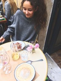 Midsection of woman sitting at restaurant table