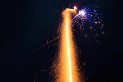 Low angle view of firework display at night