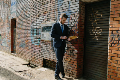 Full length of man standing against wall