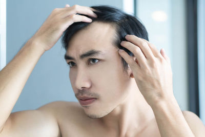 Close-up portrait of shirtless young man