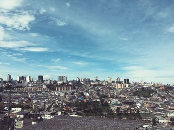 Aerial view of buildings in city against sky