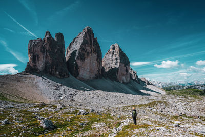 Backpacker on hiking trails in the dolomites, italy. view of the three peaks.