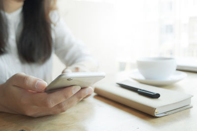Midsection of man using laptop on table