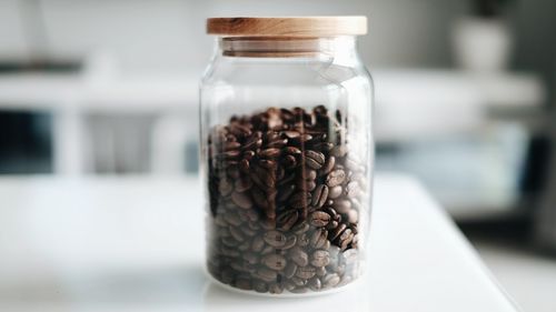 Close-up of roasted coffee beans in jar on table