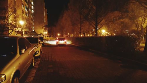 Cars on illuminated street at night