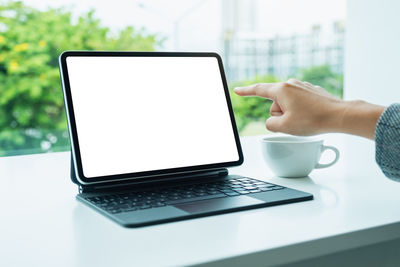 Cropped hand using laptop on table