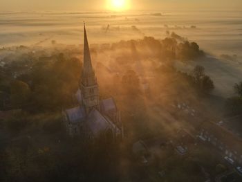 Aerial view of building against sky during sunset