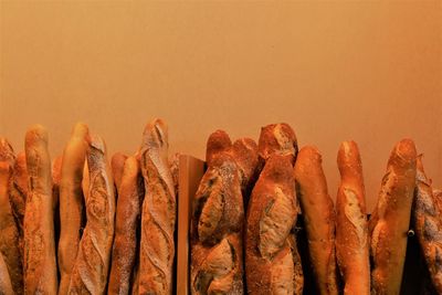 Close-up of bread loafs against orange background