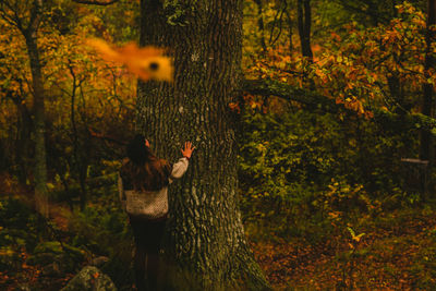 Woman with trees in forest during autumn