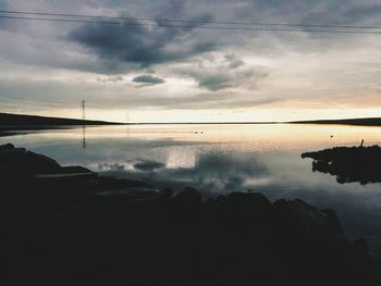 Reflection of clouds in sea at sunset