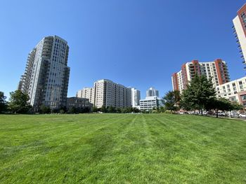 Buildings in city against clear blue sky