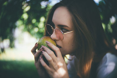 Close-up portrait of young woman holding plant