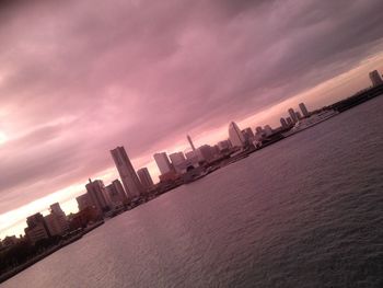 Built structures against cloudy sky at sunset