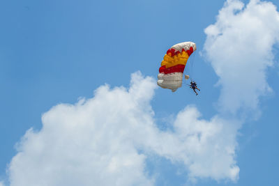 Low angle view of person paragliding against sky