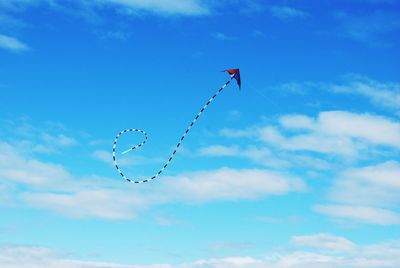 Low angle view of kite flying against blue sky