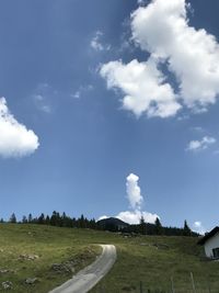 Road amidst field against sky