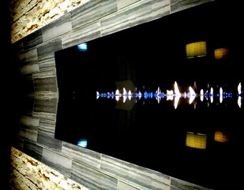 Reflection of illuminated building on glass window at night