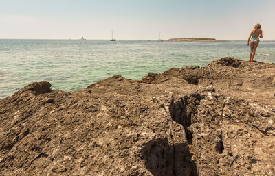 Woman looking at sea against sky