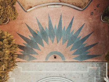 Aerial shot of female dancer in urban plaza setting with geometric pattern