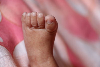 Low section of baby feet on bed