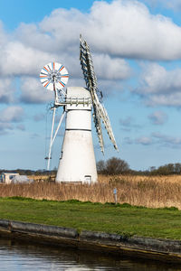 Traditional windmill on field against sky