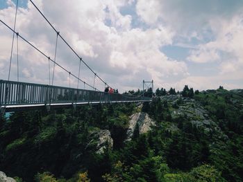 Bridge over river against cloudy sky