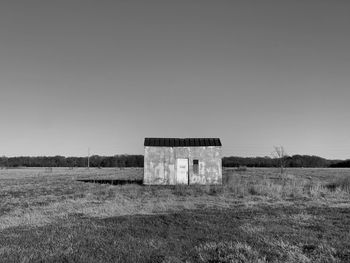 Abandoned building on field against clear sky