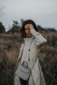 Young woman standing against sky