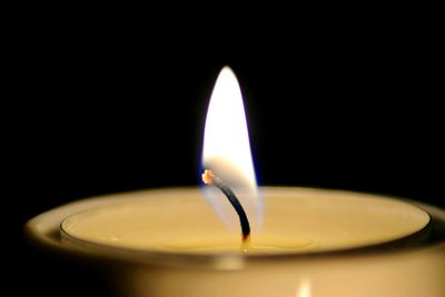 Close-up of lit candle in dark room