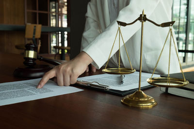 Close-up of hand holding book on table